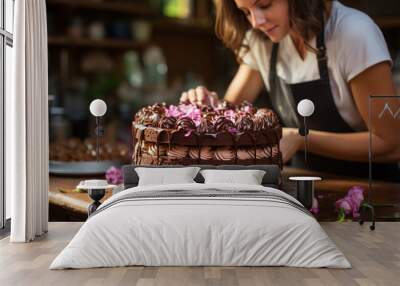 Pastry chef making a chocolate cake with cream. Woman decorating a chocolate cake. Pastry worker. Wall mural