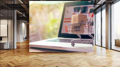 Shopping online concept - Parcel or Paper cartons with a shopping cart logo in a trolley on a laptop keyboard. Shopping service on The online web. offers home delivery.. Wall mural