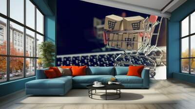 Shopping online. cardboard box with a shopping cart logo in a trolley on a laptop keyboard. Shopping service on The online web. offers home delivery.. Wall mural