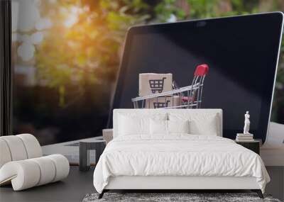 Shopping online. cardboard box with a shopping cart logo in a trolley on laptop keyboard. Shopping service on The online web. offers home delivery Wall mural