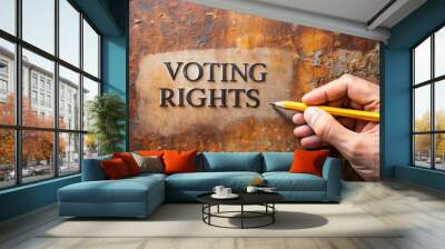 Hand holding pencil marking ballot on paper with 'Voting Rights' text written in bold font on a rusty metal background, symbolizing democracy and freedom. Wall mural