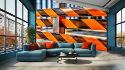 Vibrant orange and black striped warning tape coils around a metal barrier, signaling caution and alerting individuals to a hazardous or restricted area ahead. Wall mural