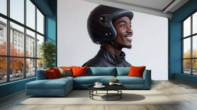  young African man wearing a black leather jacket and helmet, smiling against a white background Wall mural