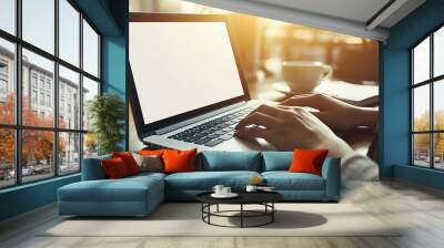 woman hands typing on a laptop with a plain white screen  sitting at a desk with a cup of coffee and a notebook Wall mural