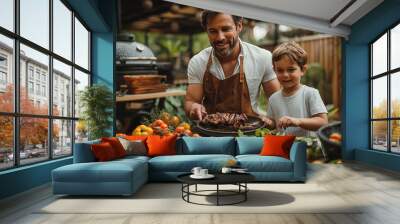 Father with little son grilling outside during family summer garden party Wall mural