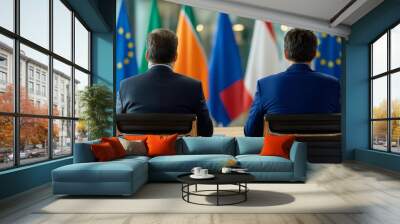 Two professionals discuss in front of international flags, symbolizing global cooperation and diplomacy. Wall mural