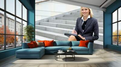 a young blond businesswoman is working outdoors Wall mural