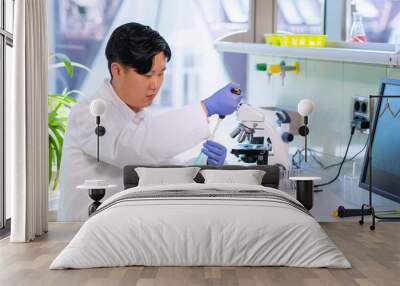 Asian scientist working in lab. Doctor making microbiology research. Laboratory tools: microscope, test tubes, equipment. Biotechnology, chemistry, bacteriology, virology, dna and health care. Wall mural