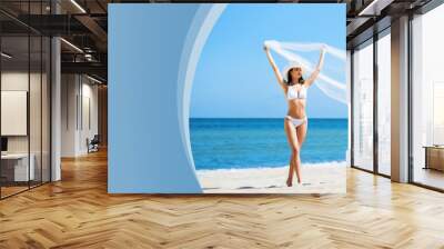 Beautiful, young and happy blond woman walking on the beach in white swimsuit. Fit and sexy fashion model in bikini. Traveling and summer resort. Wall mural