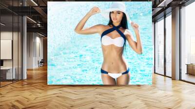 Beautiful and sporty girl relaxing in a pool Wall mural