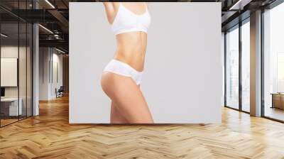 Close-up of a beautiful and fit female figure. Studio photo of young woman's body in swimsuit. Wall mural