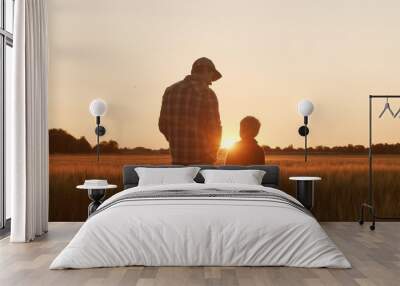 Farmer and his son in front of a sunset agricultural landscape. Man and a boy in a countryside field. Fatherhood, country life, farming and country lifestyle. Wall mural