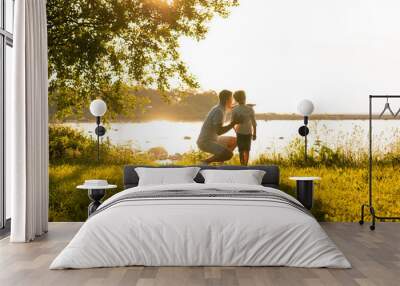 Father and his little son. Happy loving family walking outdoor in the light of sunset. Wall mural