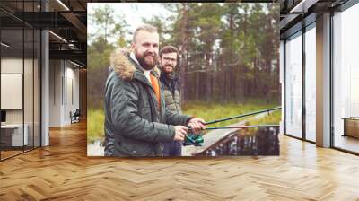 Fishermen with a spinning rod catching fish on a river Wall mural