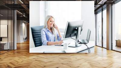 Young, attractive and confident business woman working in office Wall mural