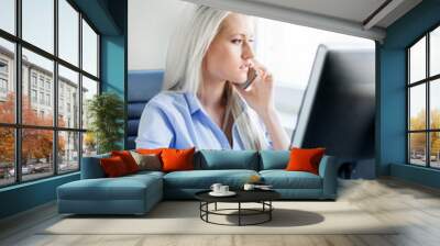 Young, attractive and confident business woman working in office Wall mural