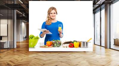 Young and beautiful housewife woman cooking in a kitchen Wall mural