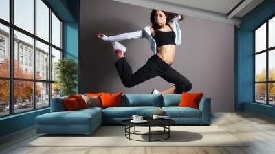 Young and sexy modern dancer over grey background Wall mural