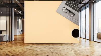 Above photo of grey laptop glasses and cup of coffee isolated on the beige backdrop with empty space Wall mural