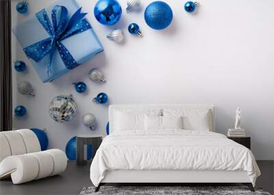 Christmas concept. Top view photo of blue white silver baubles disco balls and big giftbox with ribbon bow on isolated white background with copyspace Wall mural