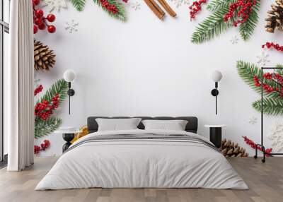 Christmas Eve concept. Top view photo of fir branches in frost mistletoe berries pine cones cinnamon sticks dried orange slices snowflakes on isolated white background with blank space in the middle Wall mural