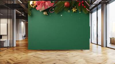 Christmas themed background featuring ornaments, a gift box with a red ribbon, and pine branches for seasonal decorations Wall mural