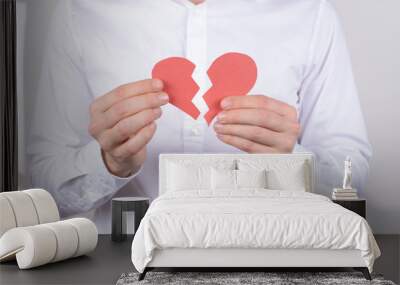 Hurt feelings marriage torn health care concept. Cropped close up photo of exhausted with bad feelings crying husband showing two halves on one heart isolated grey background Wall mural