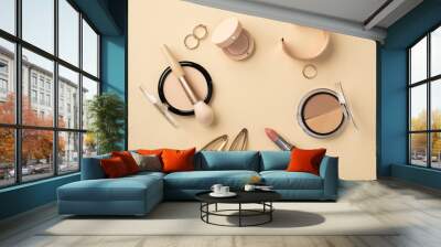 Make up concept. Top view photo of circle composition lipstick compact powder brush contouring palette eyeshadow gold wristlet rings and barrettes on pastel beige background Wall mural