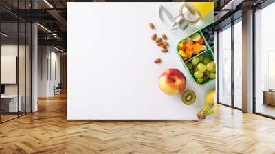 Showcase school lunch experience with a top-down image of lunchbox brimming with sandwiches, nutritious fruits, veggies and water bottle on white isolated background, offers space for text or adverts Wall mural