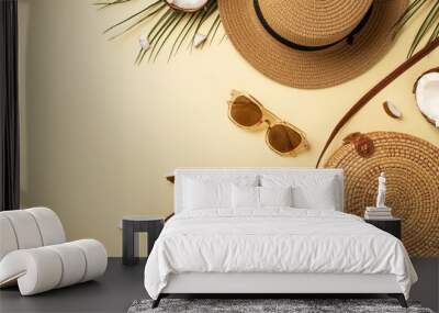 Summer vacation concept. Top view photo of sunhat round rattan bag sunglasses cracked coconuts and green palm leaves on isolated beige background Wall mural