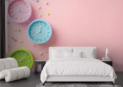 Welcome back to school. Top view of alphabet letters and three clocks set to different times, signifying lesson schedules. Pastel pink backdrop with empty space for text or advertising purposes Wall mural