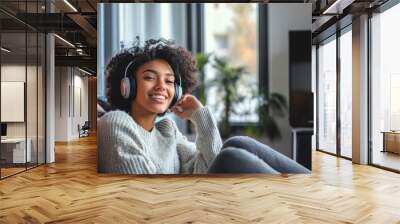 Young woman enjoying music with headphones at home, smiling and relaxed, sitting on a comfortable sofa. Generated AI Wall mural