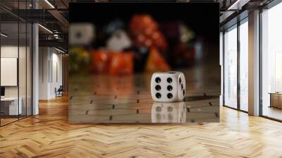 a white six-sided D6 dice with black dots, showing six dots, sitting on a hexagonal tabletop gaming board with a variety of different types of dice in the background.  Wall mural