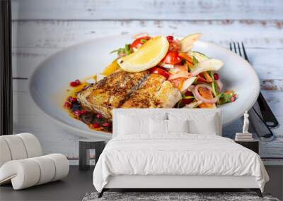 Grilled Barramundi with a side of salad, served on a white round plate with knife and fork. Wall mural