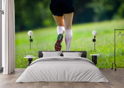  Young women jogging at park . Close-up photo of her legs Wall mural