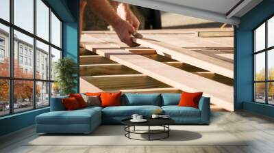 Man placing a plank of wood in a deck home renovation Wall mural