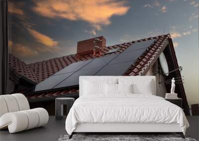 Low angle shot of a house with solar panels on the roof under a sunset sky Wall mural