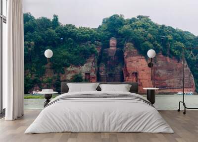 Panorama shot of the Ancient Giant Leshan Buddha in Leshan, Chengdu, Sichuan, China, the largest stone carving of the Buddha in the world, with three tour boats in front Wall mural