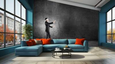 Business concept of risk with businessman wearing blindfold in empty concrete room Wall mural