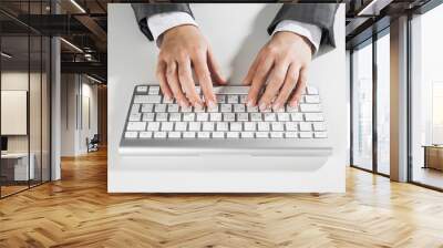 Closeup of businesswoman hand typing on keyboard with mouse on wood table Wall mural