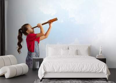 Concept of careless happy childhood with girl looking in spygl Wall mural