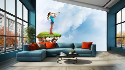 Concept of careless happy childhood with girl looking in spyglass Wall mural