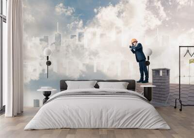 Engineer man standing on roof and looking in binoculars. Mixed m Wall mural