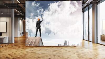 Man architect draw silhouette of modern city on blue sky. Mixed  Wall mural