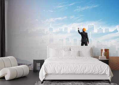 Man architect draw silhouette of modern city on blue sky. Mixed media Wall mural