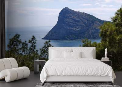 A picturesque view of a rocky sheer mountain against the backdrop of the endless blue sky Wall mural