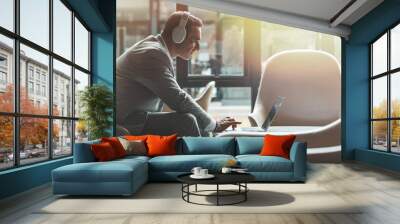 Continue what you've started. Businessman is using laptop in the office. Copy space on the right side Wall mural