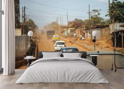 a dirt road with a yellow sign that says  taxi  on it. Yaounde city Wall mural