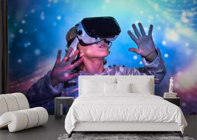 Delighted kid interacting with VR glasses in neon lights Wall mural