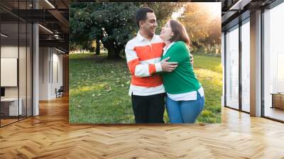 Embracing couple enjoying a sunset in the park Wall mural